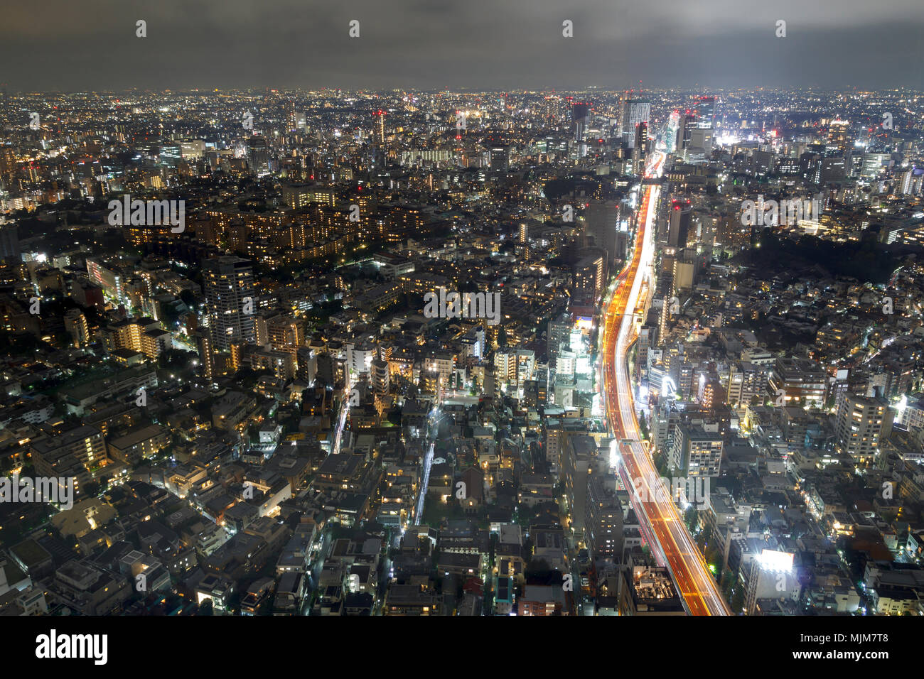 La vista della citta' di Tokyo di notte con una autostrada che attraversa gli edifici Foto Stock