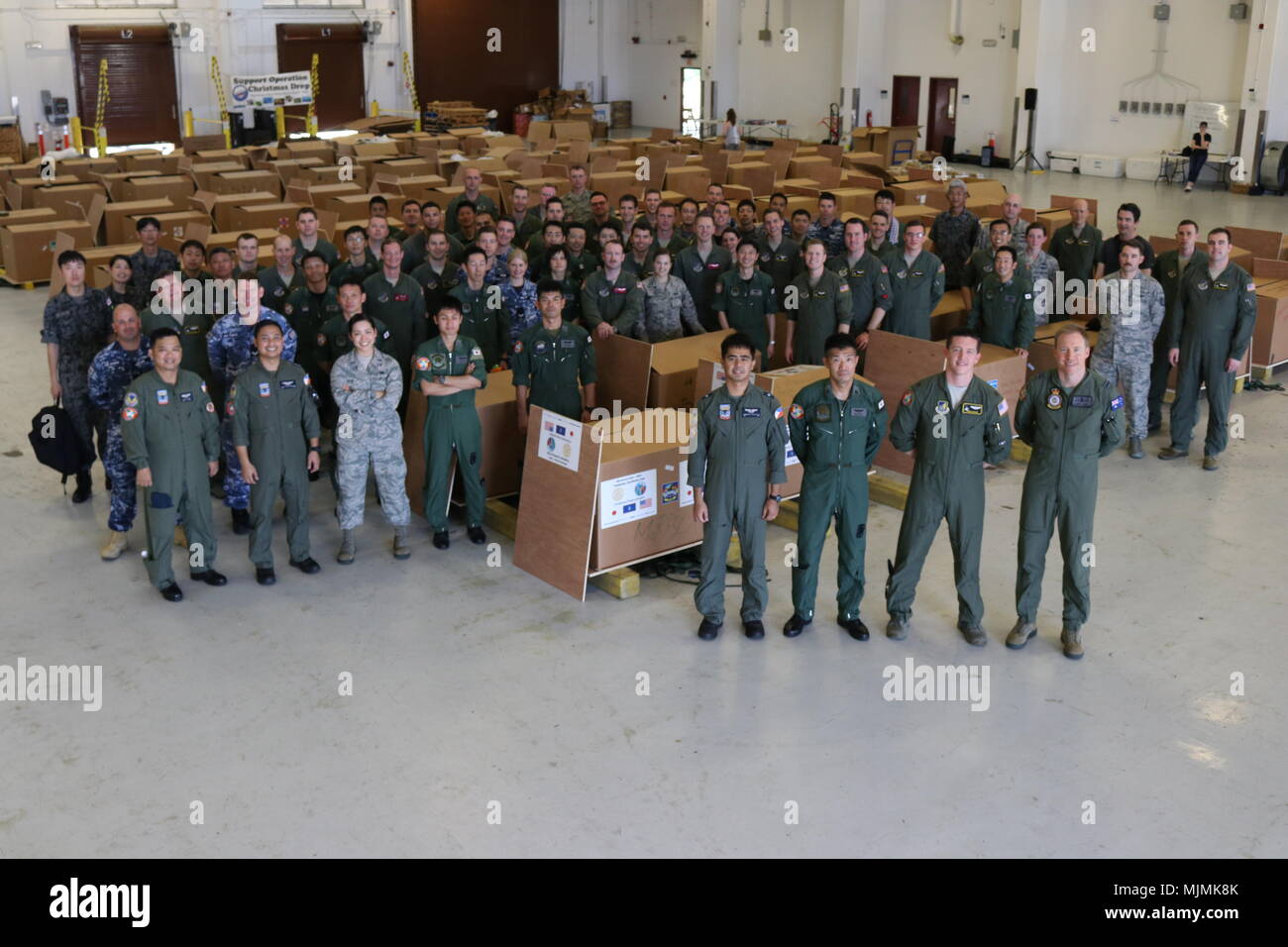 L'operazione Christmas Drop è una missione umanitaria di lancio aereo con sede nel Pacifico organizzata dalla United States Air Force e dalle nazioni partner. Il personale della United States Air Force, Philippine Air Force, Royal Australian Air Force e Japan Air Self-Defense Force si riuniscono vicino al carico preparato presso la Andersen Air Force base, Guam, il 9 dicembre 2017, per la 66a missione. L'immagine di archivio documenta il coordinamento trilaterale prima dei voli di consegna della fornitura. Foto Stock
