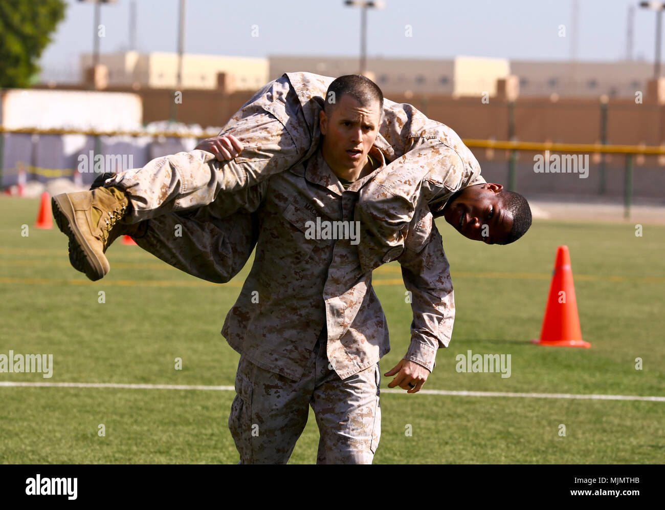 Supporto navale attività BAHRAIN (dec. n. 13, 2017) - Naval Amphibious vigore, Task Force 51/5th Marine Expeditionary della brigata Capt. Andrew Macon porta Sgt. Nicholas Smith sul nuovo supporto navale attività Bahrain softball campo durante la loro annuale combattere Fitness Test della manovra-sotto-porzione di fuoco dell'evento. Indipendentemente dall'età o il rango di Marines sono necessarie per condurre due fisiche test fitness annualmente - CFT e un benessere fisico prova. Il CFT è destinato a mantenere marines pronti per il fisico dei rigori contemporaneo di operazioni di combattimento e è stato progettato per simulare molte delle attività che un Mari Foto Stock