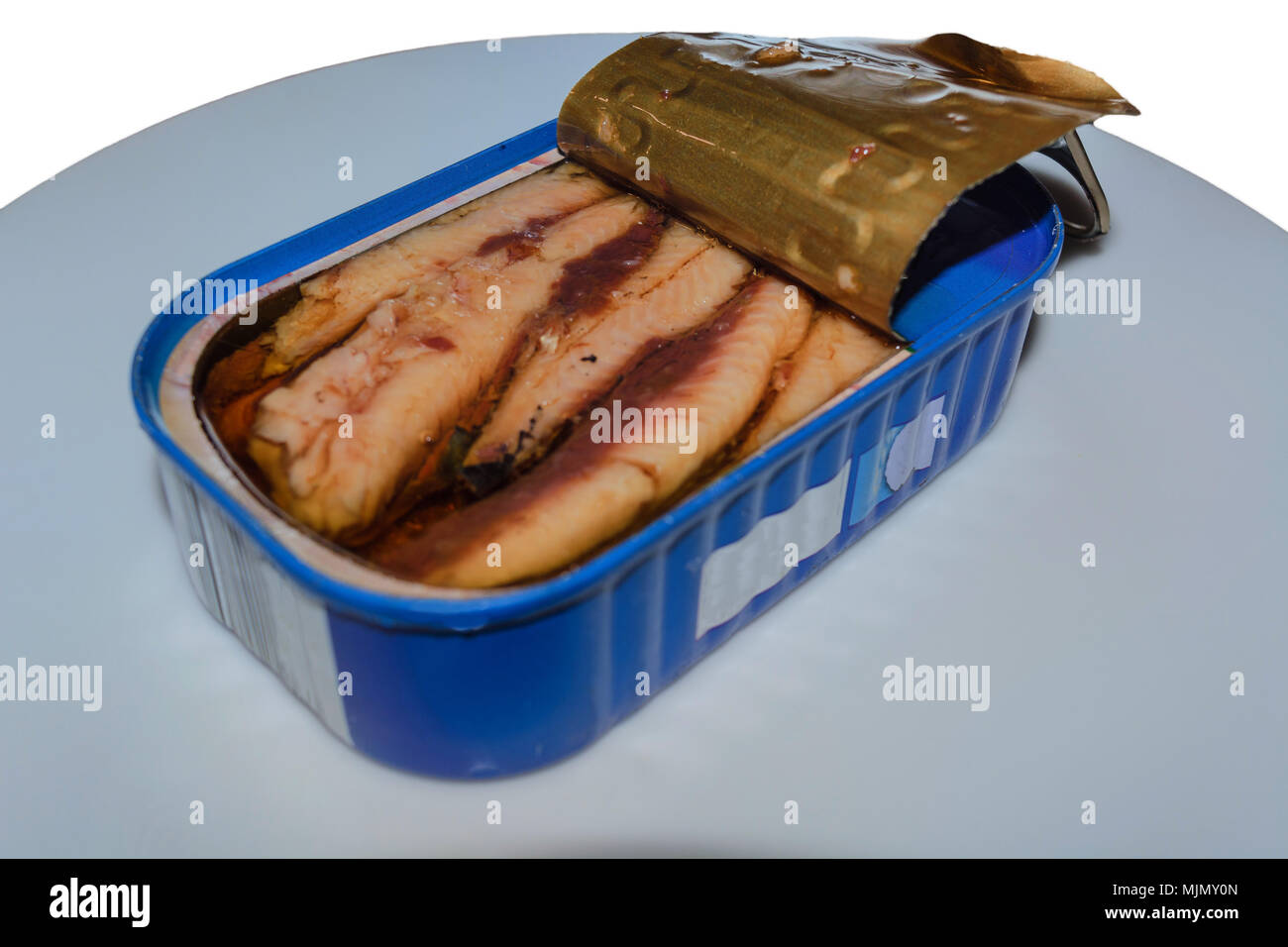 Possono le sardine su una piastra bianca con una fetta di pane. Foto Stock