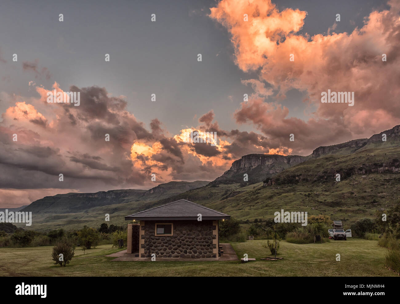 INJISUTHI, SUD AFRICA - 19 Marzo 2018: Tramonto sulla zona campeggio a Injisuthi nel Maloti Drakensberg Park. L abluzione edificio e t del raccoglitore Foto Stock