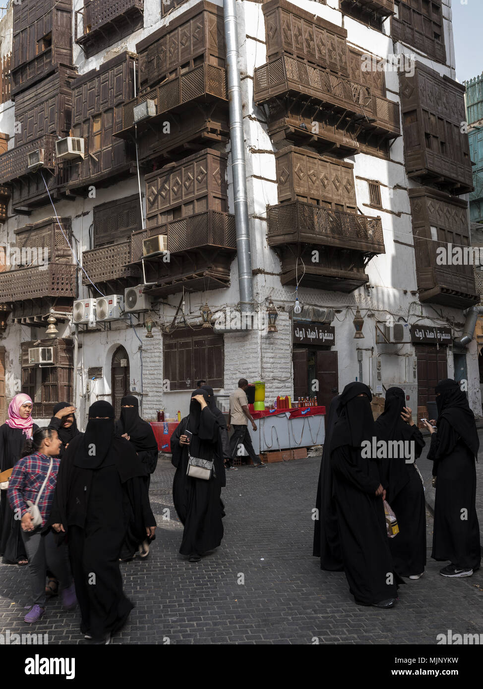 Donne saudite camminando per le strade di Al Balad, la sezione storica di Jeddah, Arabia Saudita vestita di nero abayas Foto Stock