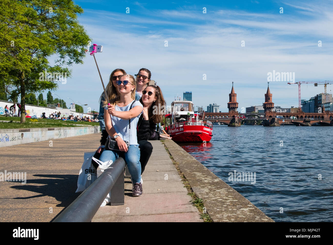 Berlino, Germania - maggio 2018: un gruppo di ragazze rendendo selfie foto al muro di Berlino (East side gallery) accanto al fiume Sprea a Berlino, Germania Foto Stock