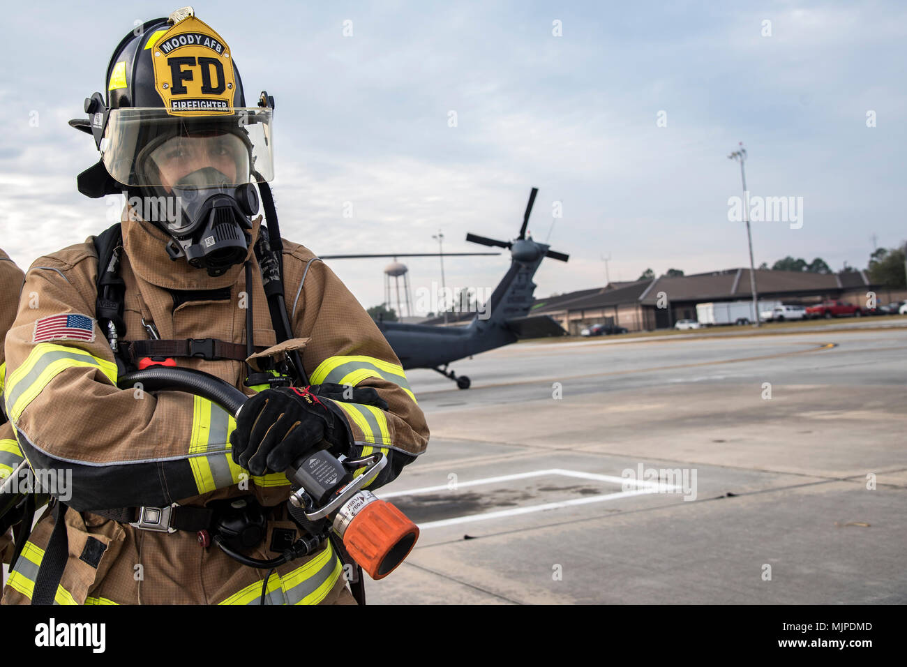 Un vigile del fuoco dal 23d' ingegnere civile Squadron (CES) detiene una manichetta antincendio, Dic 15, 2017, a Moody Air Force Base, Ga. I membri dal 723d Manutenzione aeromobili Squadron (AMXS) e 23d' ingegnere civile Squadron (CES) hanno partecipato ad una giornata di formazione per aiutare a migliorare la loro disponibilità e ottenere ulteriore pratica presso i loro mestieri. Il AMXS eseguita manutenzione su elicotteri e il CES condotte le operazioni di soccorso per spegnimento di una simulazione di incendio entro un HH-60G Pave Hawk e di estrazione di feriti vittime. (U.S. Air Force foto di Airman Eugene Oliver) Foto Stock