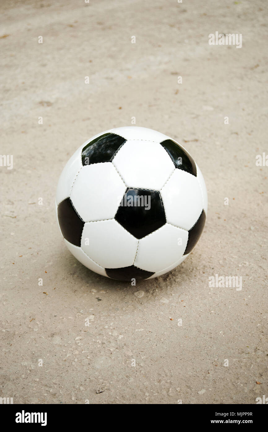 Pallone da calcio in bianco e nero sul terreno Foto Stock