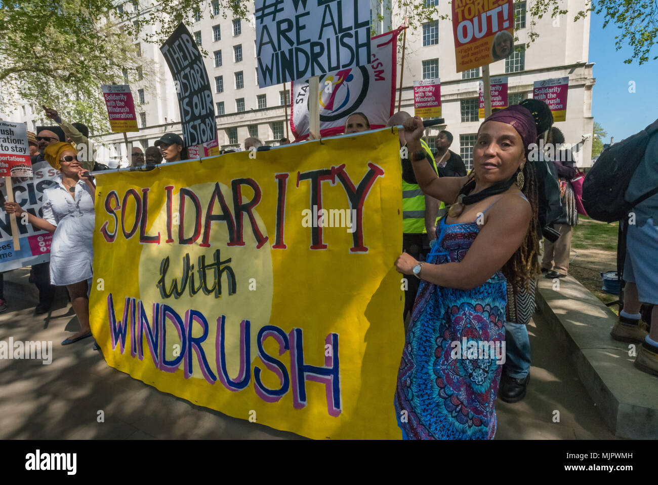 Londra, Regno Unito. Il 5 maggio 2018. Persone tenere la "solidarietà con Windrush' banner presso lo stand fino al razzismo al rally di Downing St chiamando per Theresa Maggio razzista di immigrazione 2014 atto ad essere abrogate e un fine immediato per la deportazione e la detenzione di cittadini del Commonwealth, con quelli già deportati a essere comprato indietro per il Regno Unito. I manifestanti hanno chiesto protezione per la garantita per tutti i cittadini del Commonwealth e per quelli interessati ad essere compensati per la deportazione, minacce di deportazione, detenzione, perdita delle abitazioni, posti di lavoro, benefici e attacchi di tipo denial of NHS di trattamento. Ci dovrebbe essere un fine al "ho Foto Stock