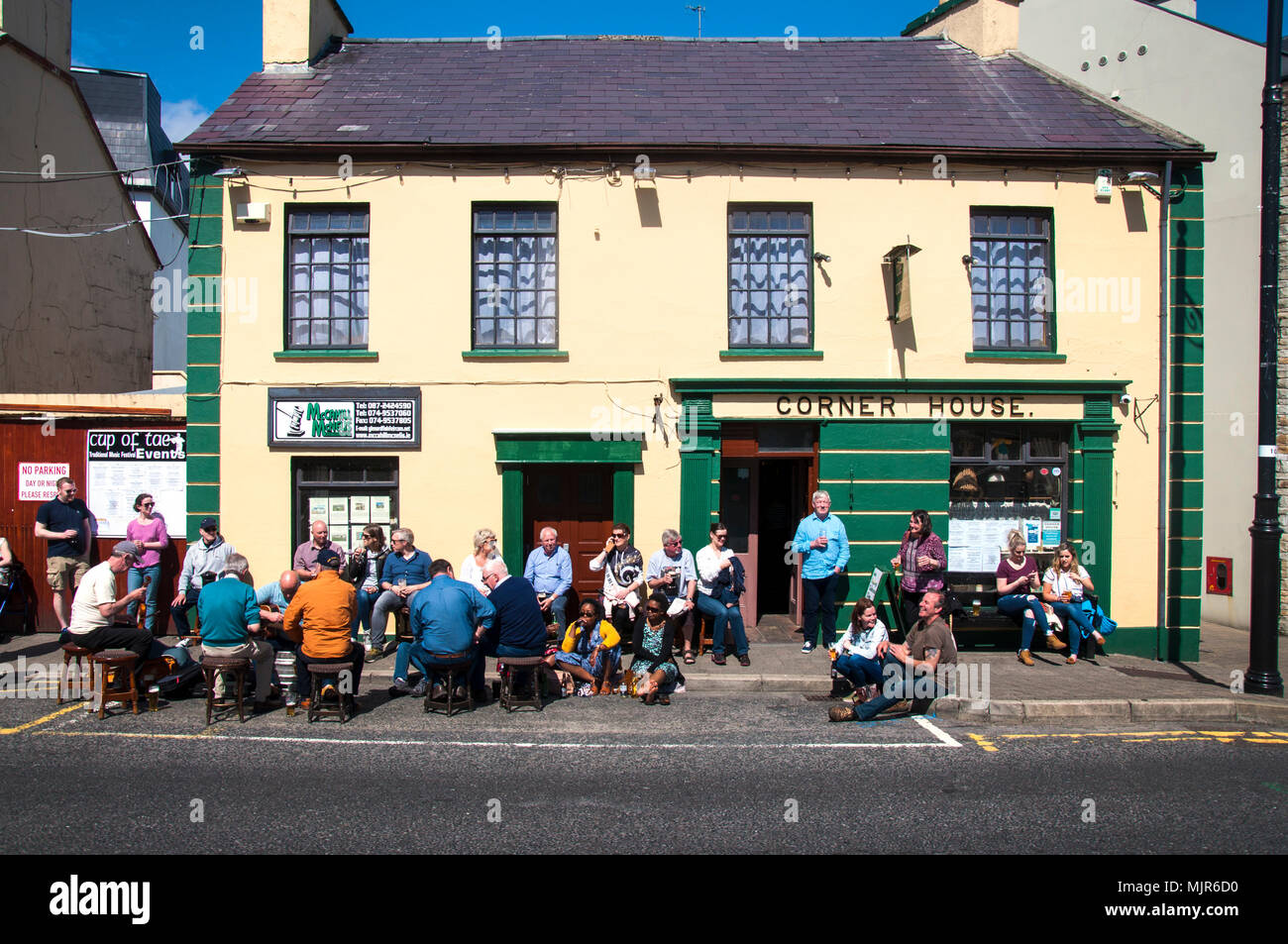 Ardara, County Donegal, Irlanda meteo. Il 6 maggio 2018. Persone sedersi al di fuori dell'angolo bar della casa sulla costa occidentale dell'Irlanda in una giornata di sole di tempo caldo. Credito: Richard Wayman/Alamy Live News Foto Stock