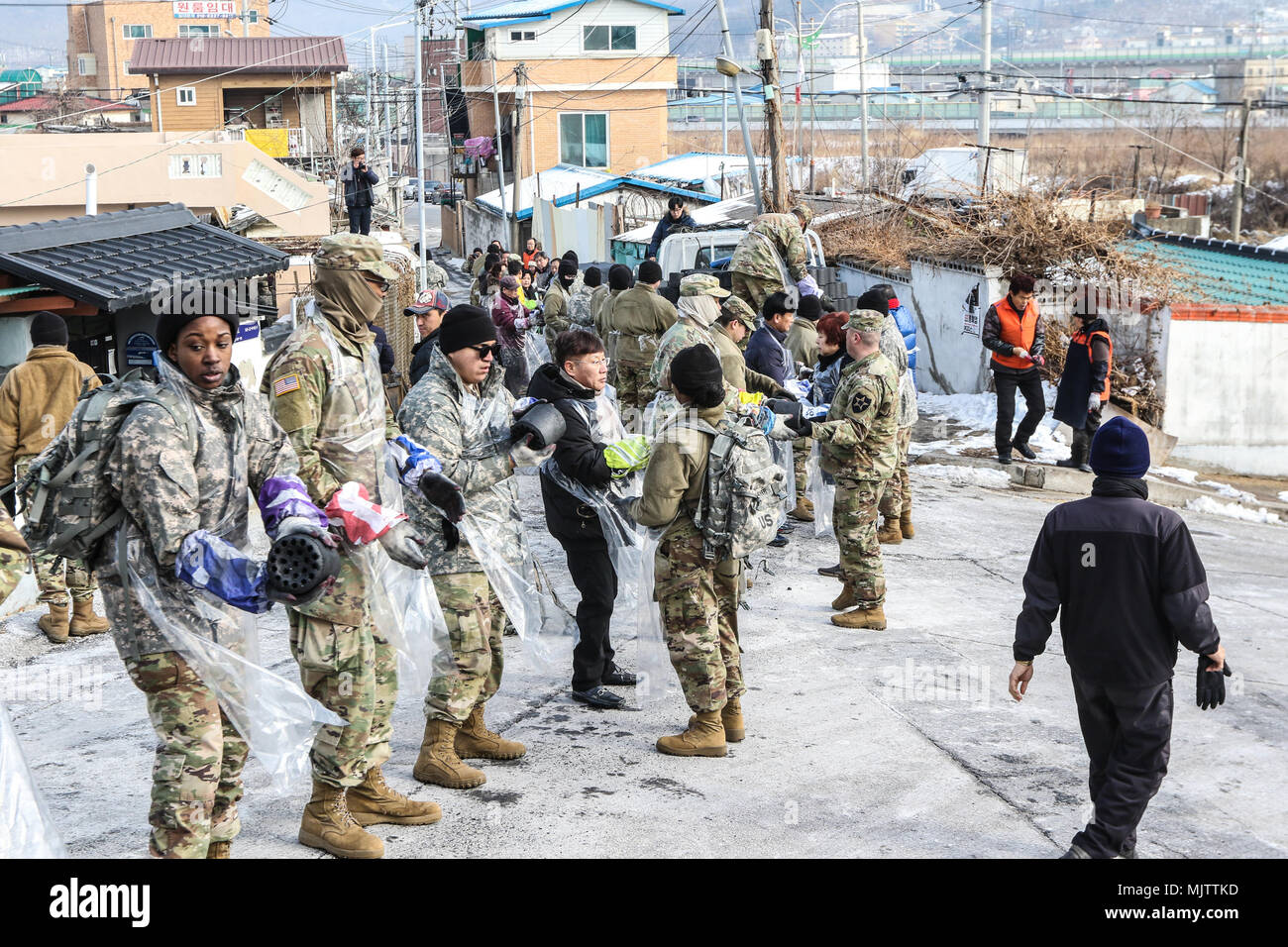 I partecipanti si alzano in una linea e consegnare bricchette di carbone al partecipante successivo in Dongducheon, Repubblica di Corea, Dic 20, 2017. Il caso è stato quello di rafforzare il rapporto tra l esercito e le comunità locali fornendo fonti di calore per i bisognosi residenti per il loro soggiorno attraverso l'inverno. (U.S. Esercito foto di PFC. Keonhee Lee, 210th FA BDE PAO) Foto Stock