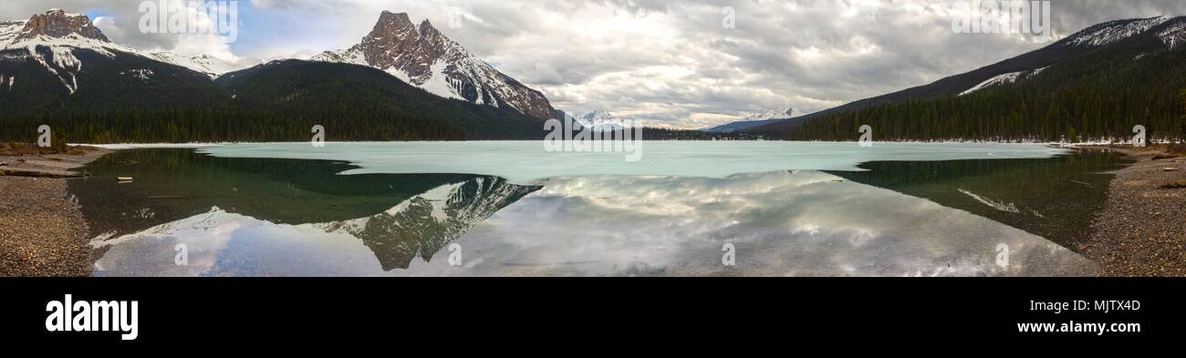 Ampia panoramica primavera vista orizzontale della Scenic Lago Smeraldo e drammatici Cloudscape nel Parco Nazionale di Yoho, Canadian Rocky Mountains Foto Stock