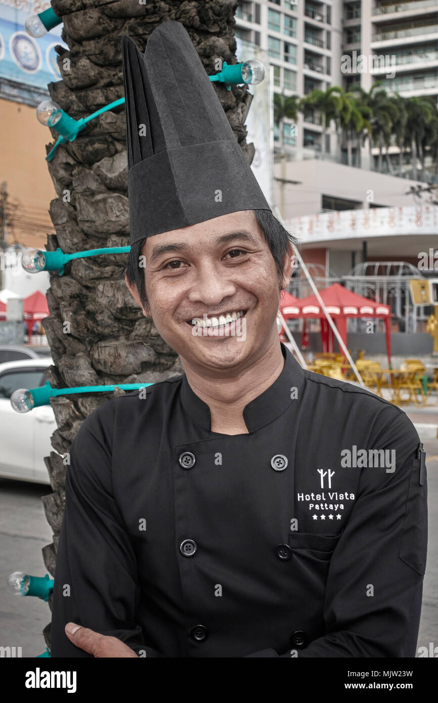 Ritratto di un chef asiatico che indossano il tradizionale uniforme e hat. Thailandia del sud-est asiatico Foto Stock