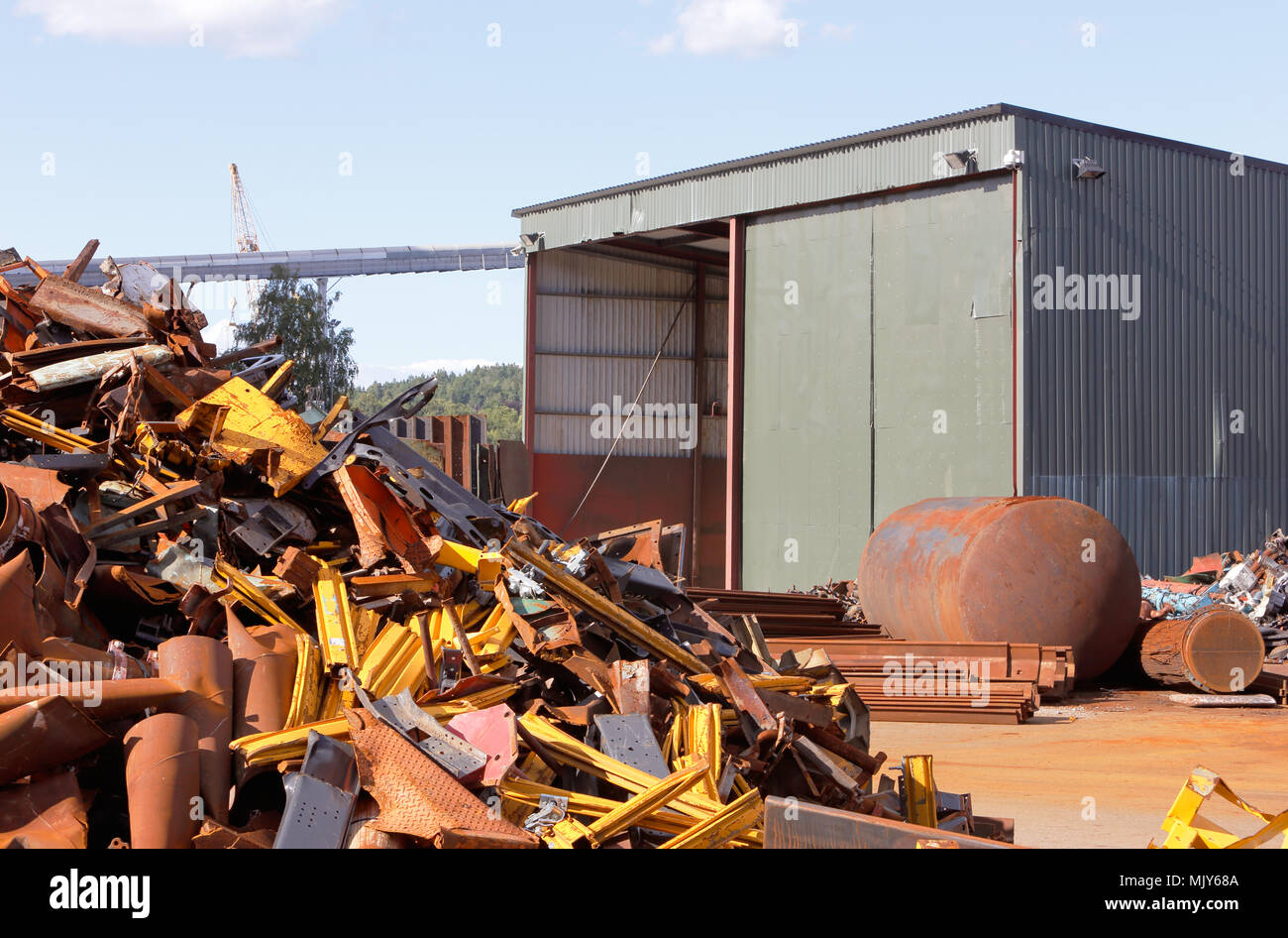 Junk jard con un capannone e un mucchio di rottami di metallo. Foto Stock