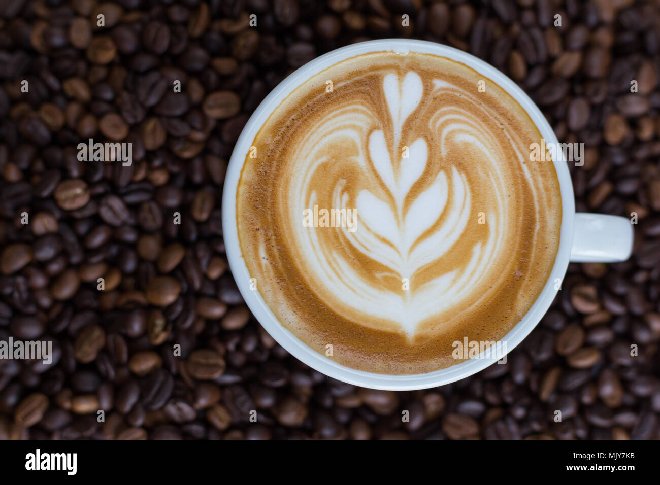 Tazza di latte caldo arte e caffè chicco di caffè. Foto Stock