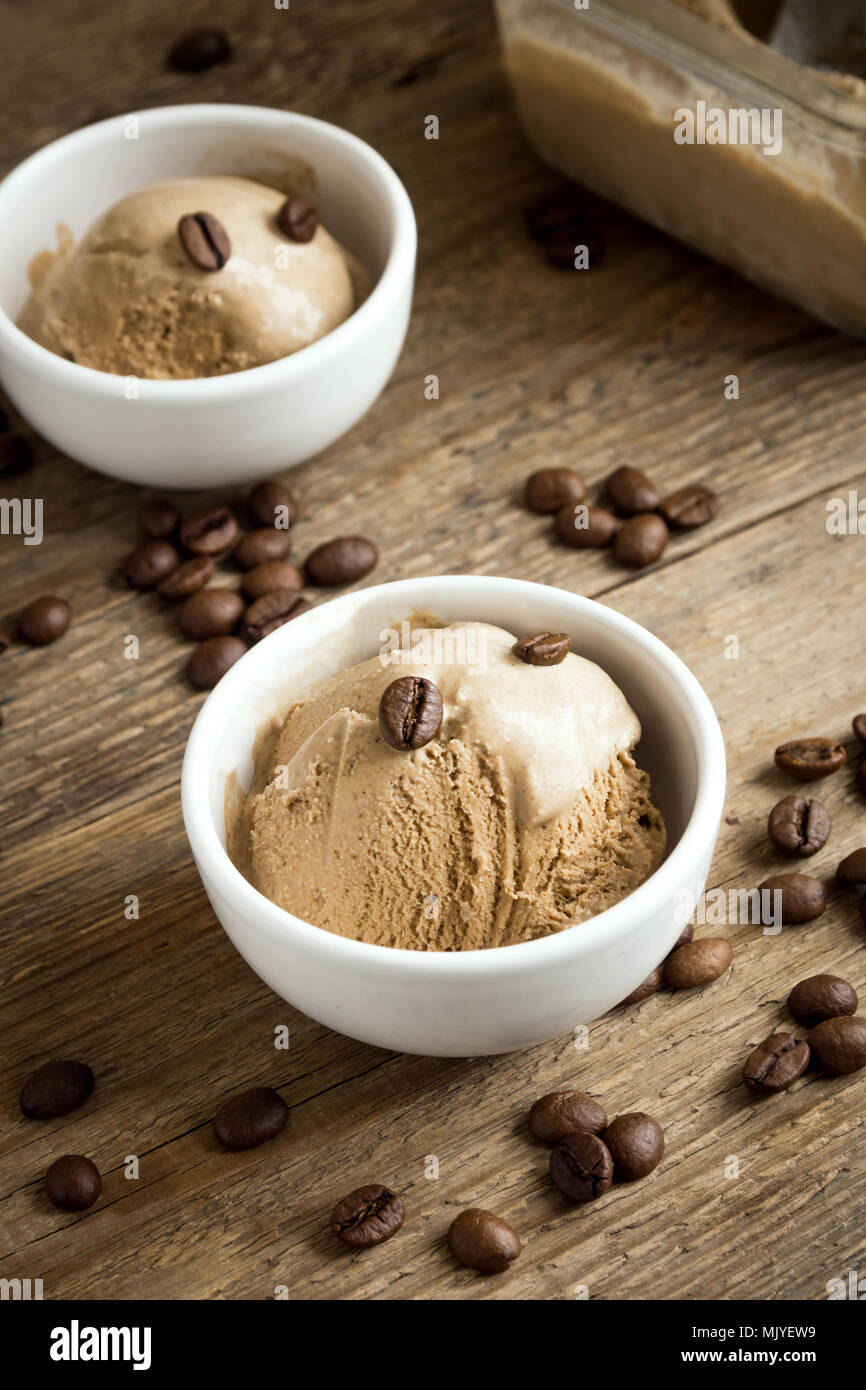 Gelato al caffè su sfondo di legno. In casa Caffè gelato Gelato con i chicchi di caffè - estate sano vegan dessert. Foto Stock