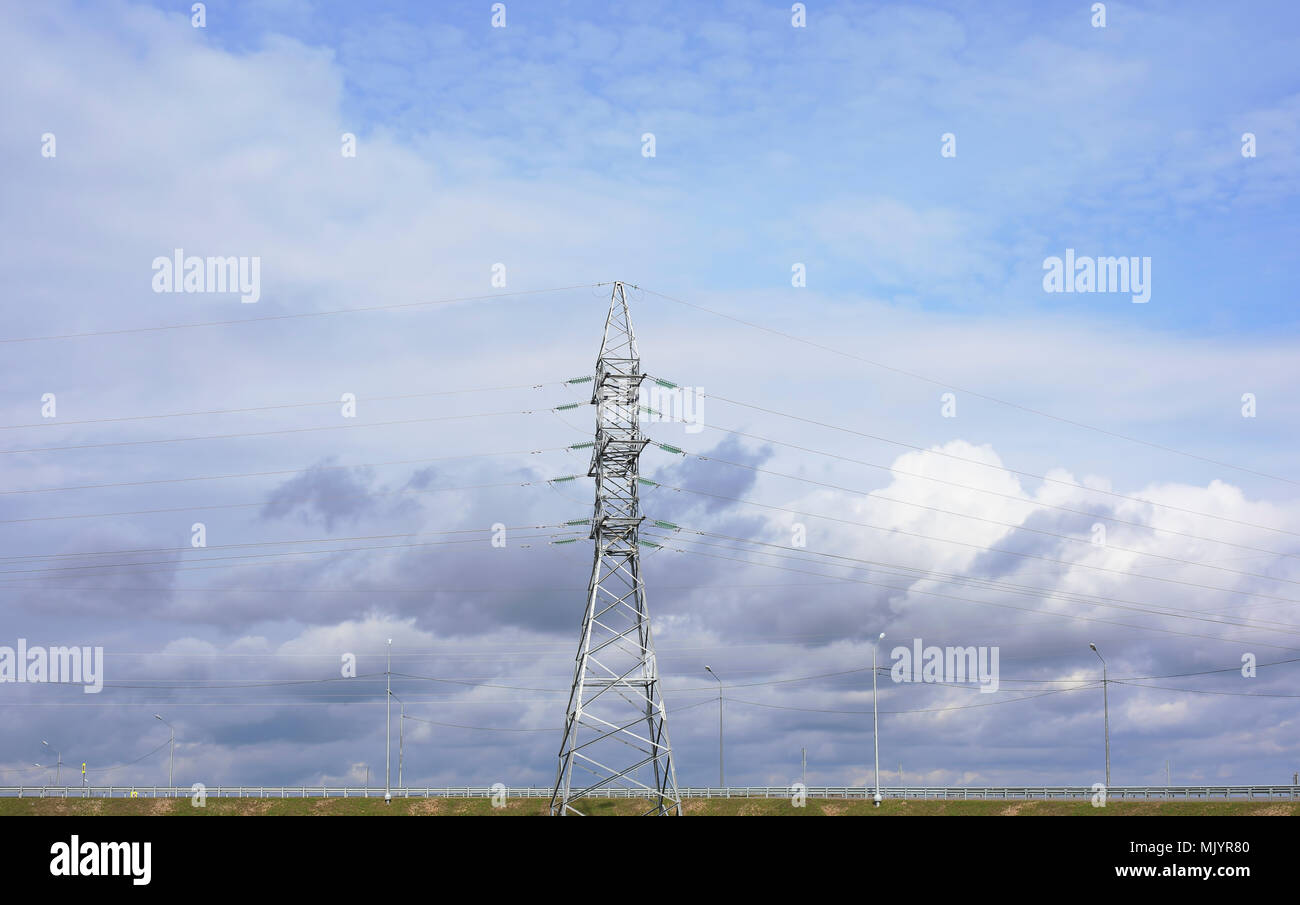 Linea ad alta tensione e potenza pilone sul cielo blu con il bianco e il grigio nuvole Foto Stock