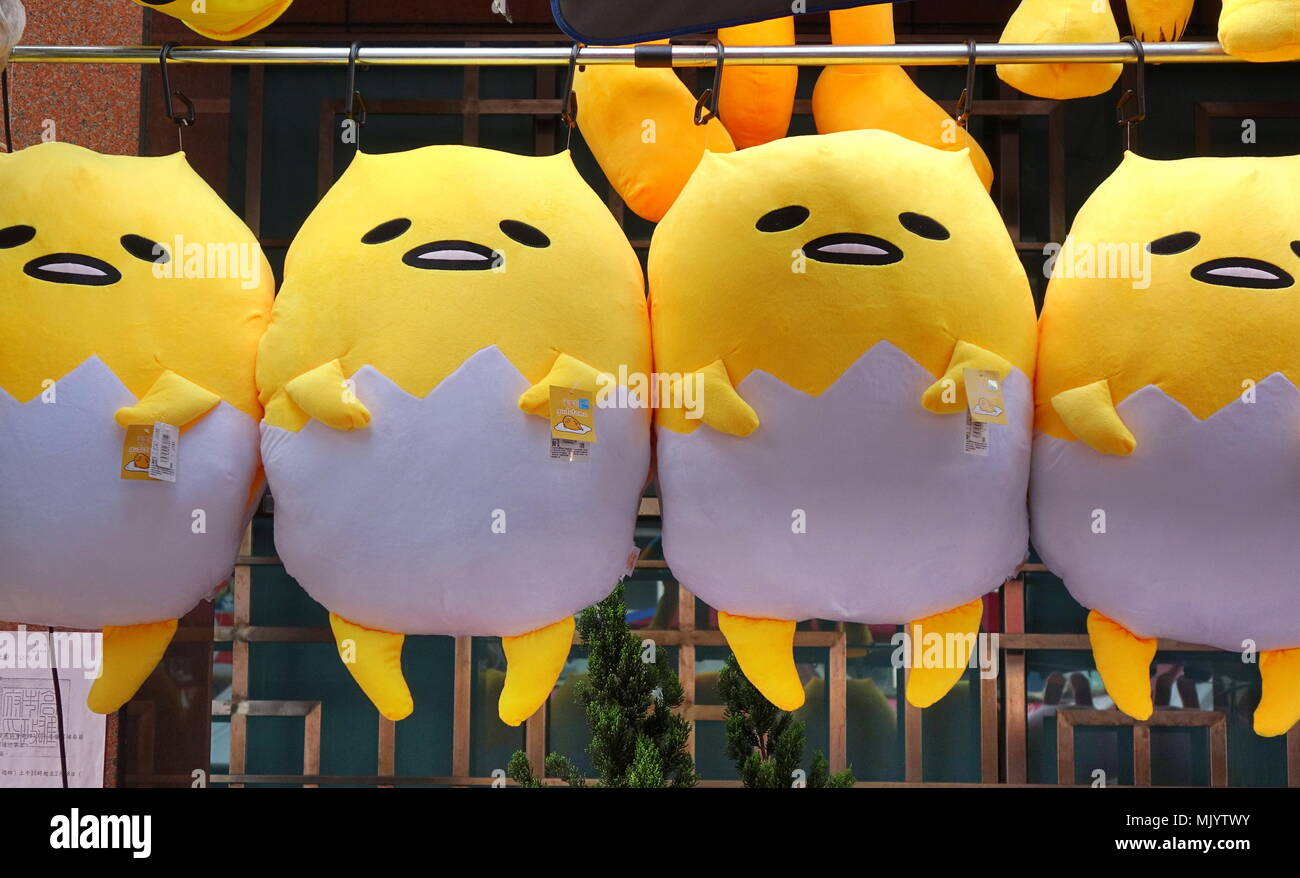 KAOHSIUNG, Taiwan -- Febbraio 17, 2018: un venditore ambulante vende bambole di grandi dimensioni basati su cartoon giapponesi Gudetama carattere. Foto Stock