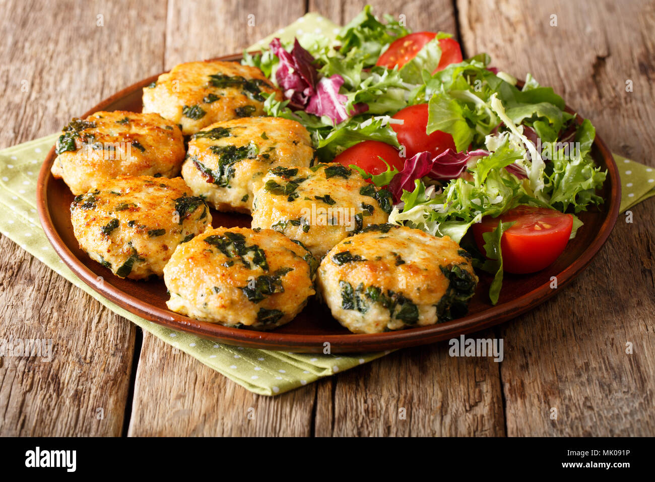 Alimenti dietetici: sfere di pollo con spinaci e formaggio e insalata di verdure close-up su una piastra su un piano orizzontale. Foto Stock