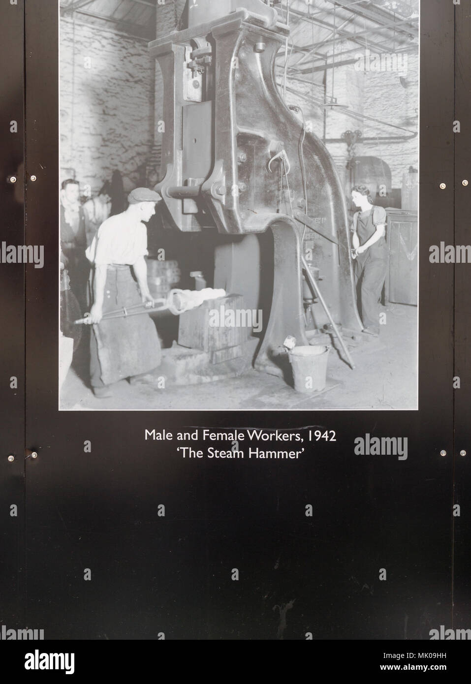 Public display del vecchio e storico immagini sulle opere di GWR, Swindon, Wiltshire, Inghilterra, Regno Unito lavoratori di sesso maschile e di sesso femminile 1942 il martello a vapore Foto Stock