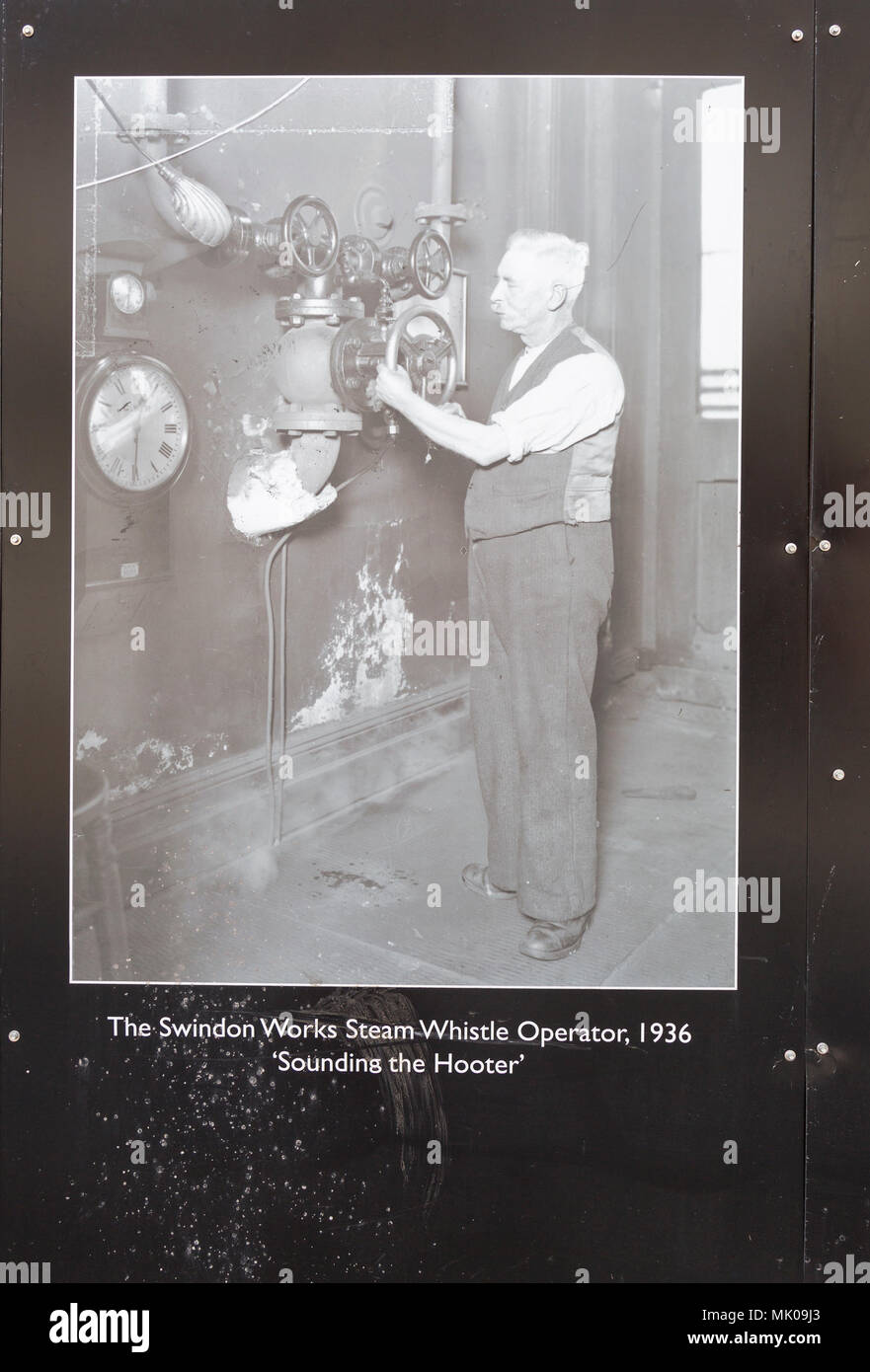 Public display del vecchio e storico immagini sulle opere di GWR, Swindon, Wiltshire, Inghilterra, Regno Unito fischio del vapore operatore 'Sounding l' avvisatore acustico Foto Stock