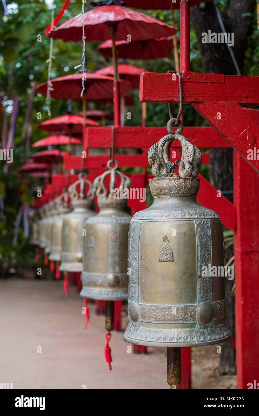 Red campane e ombrelloni in un tempio buddista in Chiang Mai, Thailandia, Sud Est asiatico Foto Stock