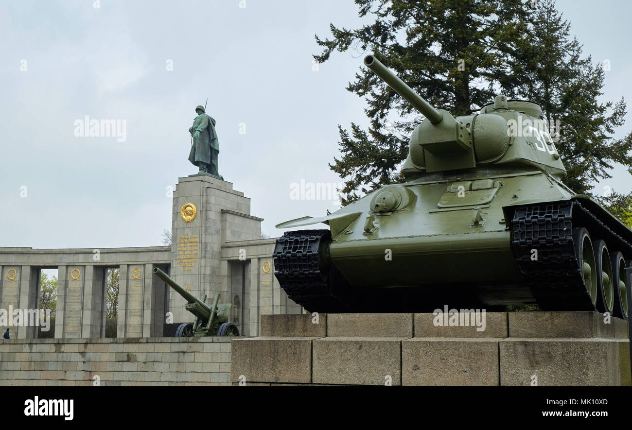 Berlino, Germania - 14 Aprile 2018: carro armato sovietico T-34 e cannone di artiglieria con statua del soldato sovietico sullo sfondo a guerra sovietica Memorial Tiergarten Foto Stock