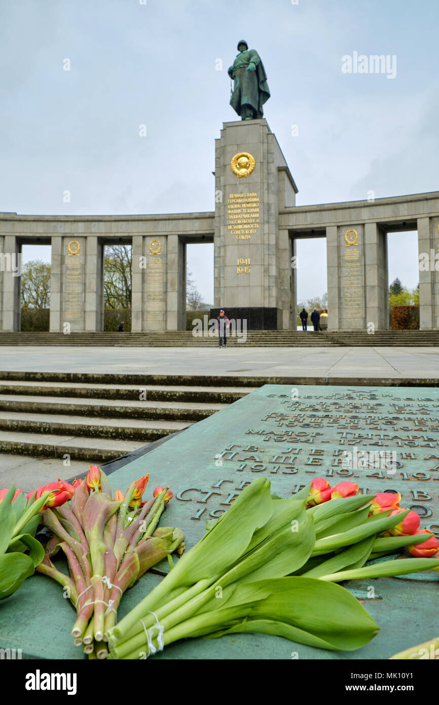 Berlino, Germania - 14 Aprile 2018: Tulipani sulla lapide con i nomi di scolpita dell Unione Sovietica eroi nella parte anteriore della statua in bronzo del soldato sovietico Foto Stock