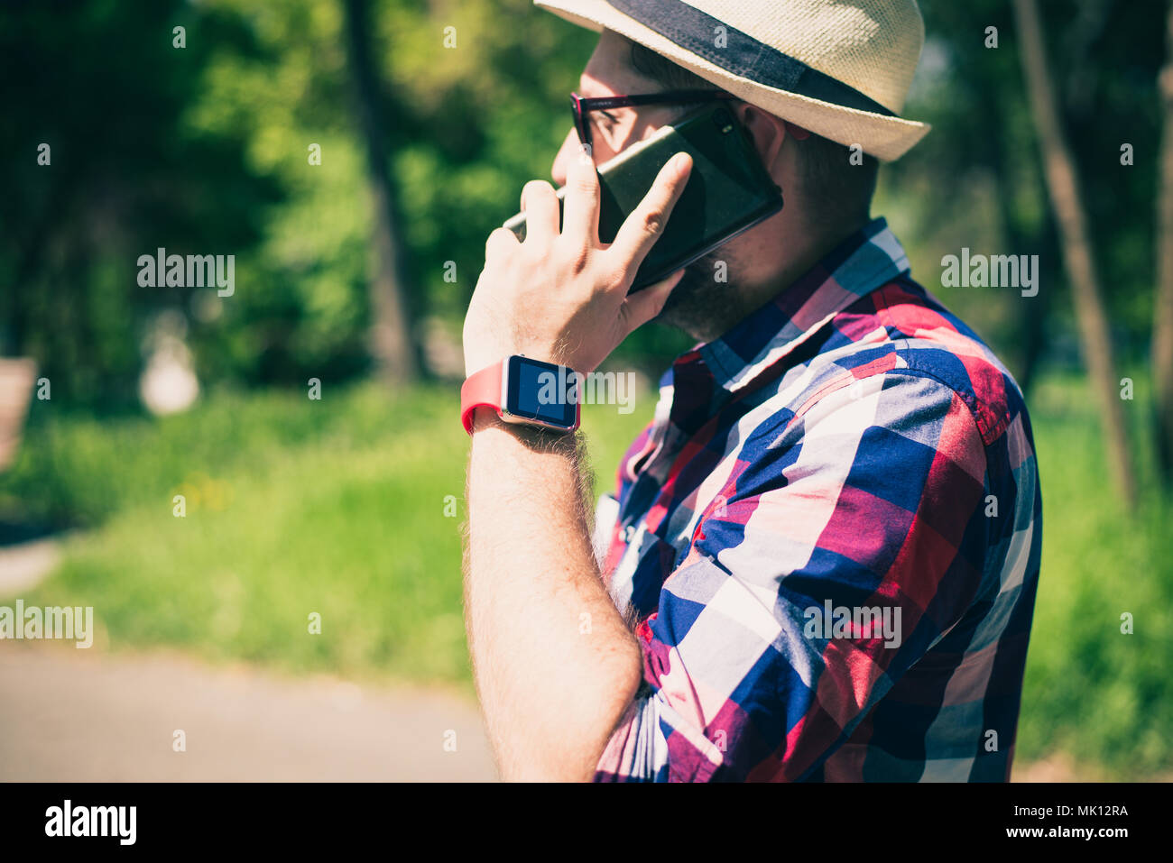 Bucarest, Romania - 26 Ottobre 2017: Persona utilizzando smart watch e uno smartphone a piedi per il parco in una domenica. Giovane uomo compiendo gesti su una usura Foto Stock