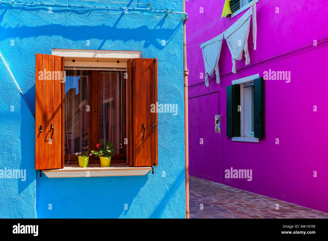 Le pareti dipinte in colori vivaci con finestre e persiane di legno a Burano, Italia. Foto Stock