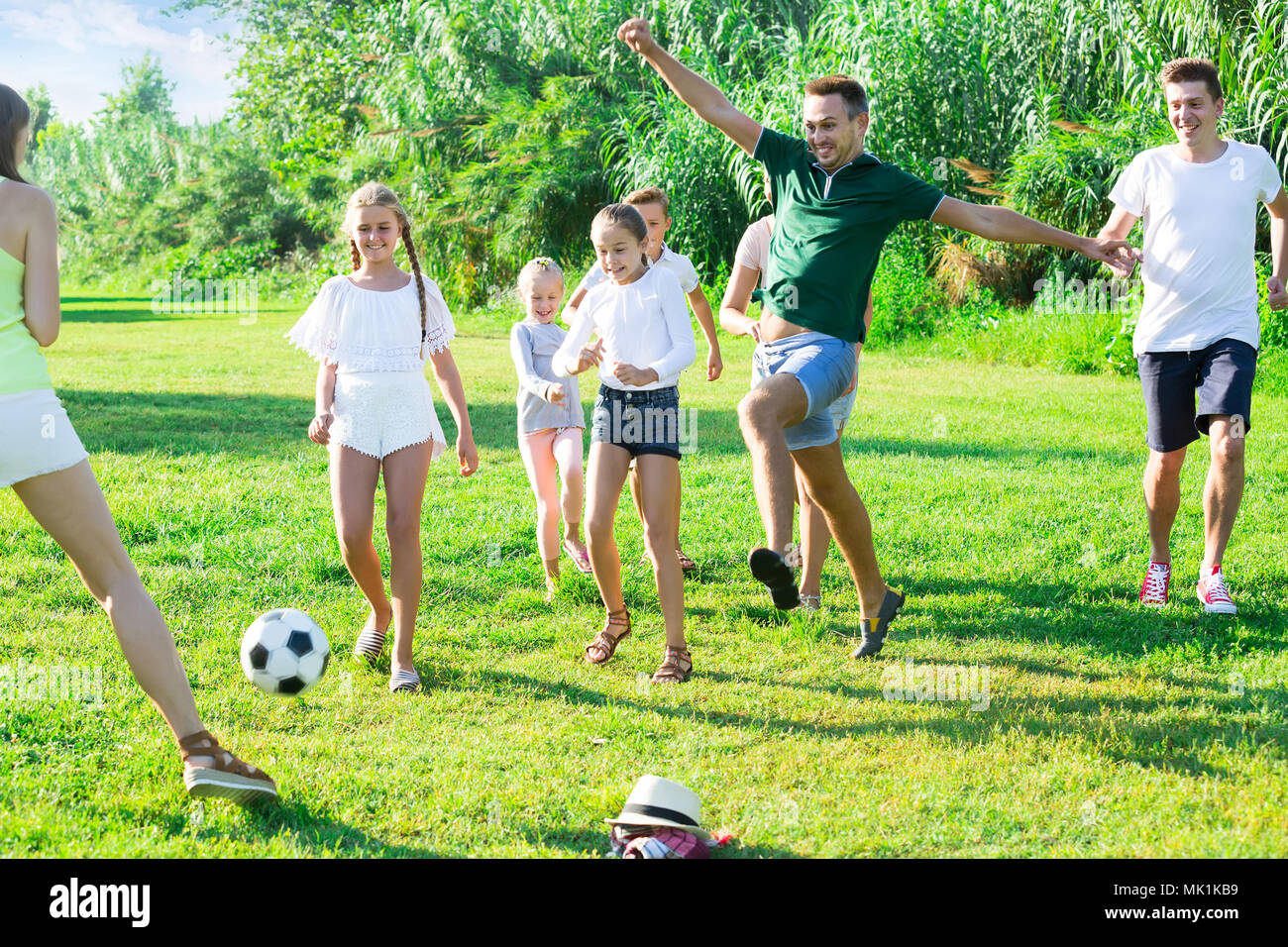 Due felice amichevole francese le famiglie con i bambini a giocare a calcio in natura in estate Foto Stock