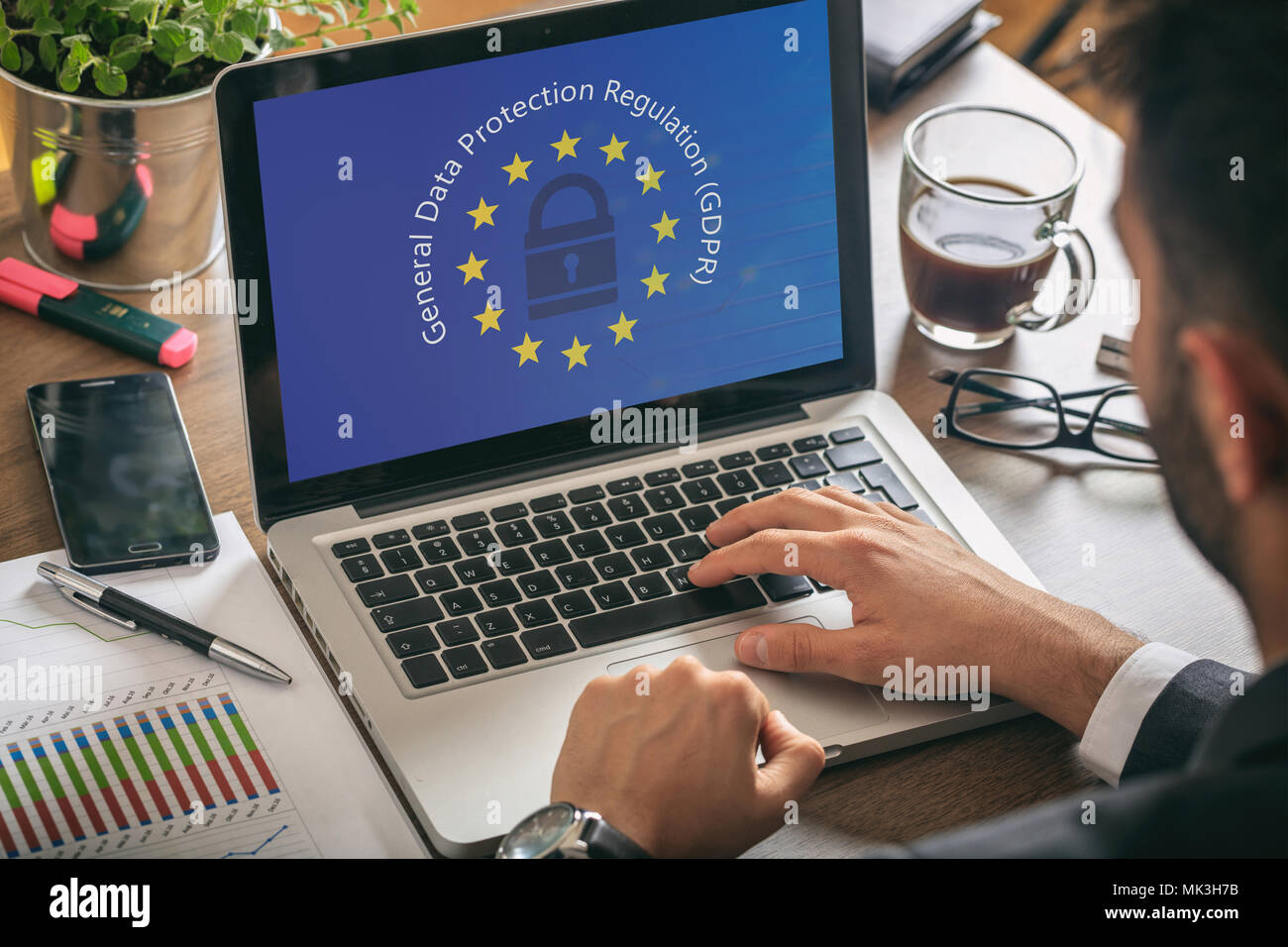 Il PILR UE. Uomo che lavora con un computer, generale della protezione dei dati il Regolamento e la bandiera dell'Unione europea sullo schermo Foto Stock