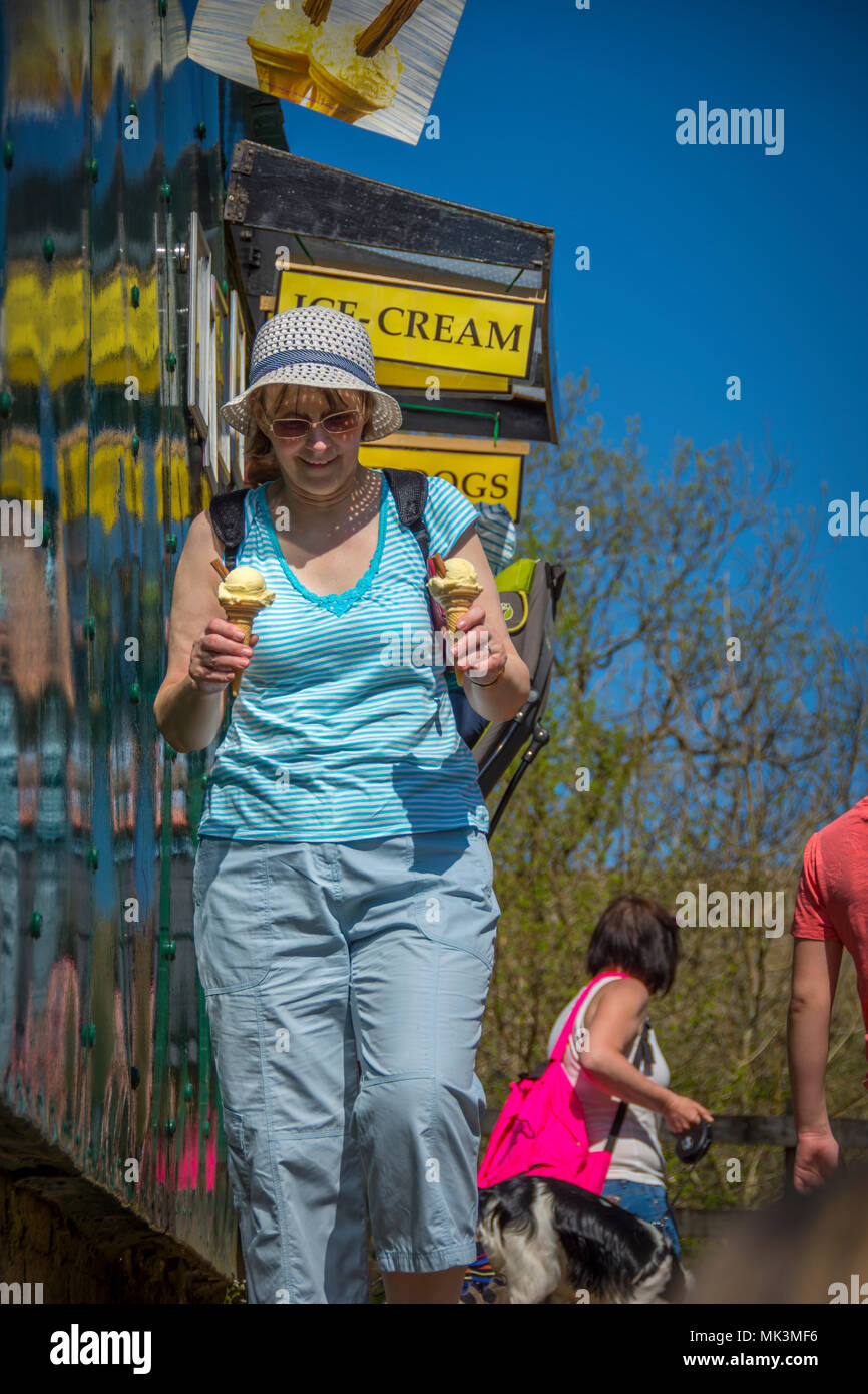 Donna con 99 gelati su una calda giornata di sole Foto Stock