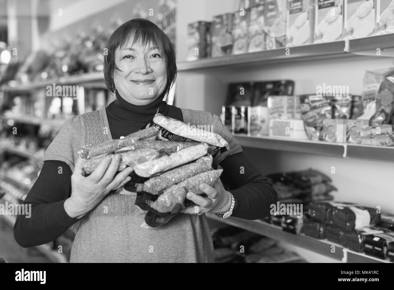 Adulto donna positivo cliente azienda Assortimento di grano saraceno negozio di alimentari Foto Stock