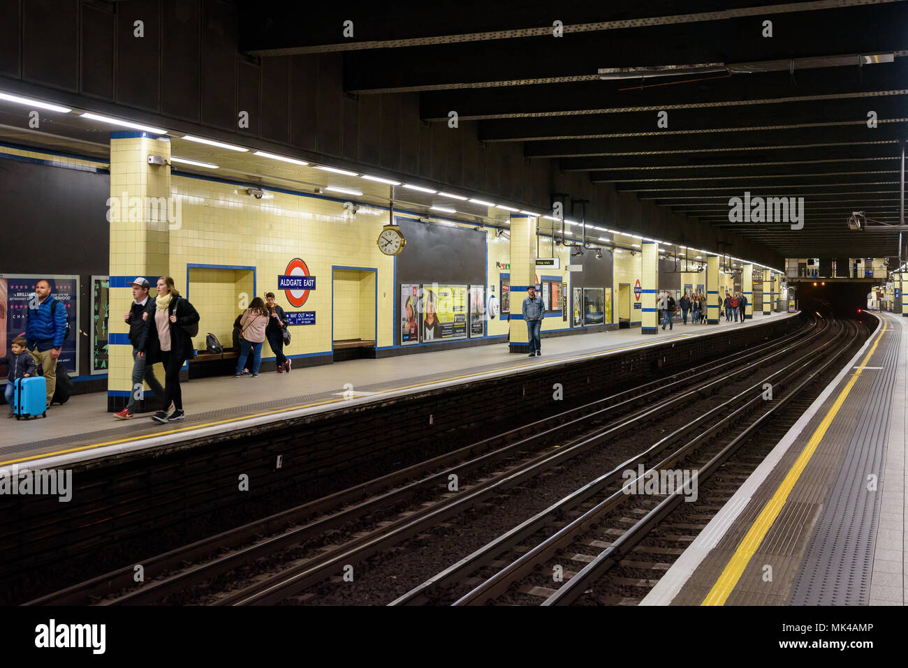 London, Regno Unito - Appril 28, 2018: persone in attesa sulla piattaforma a Aldgate East Stazione della metropolitana Foto Stock
