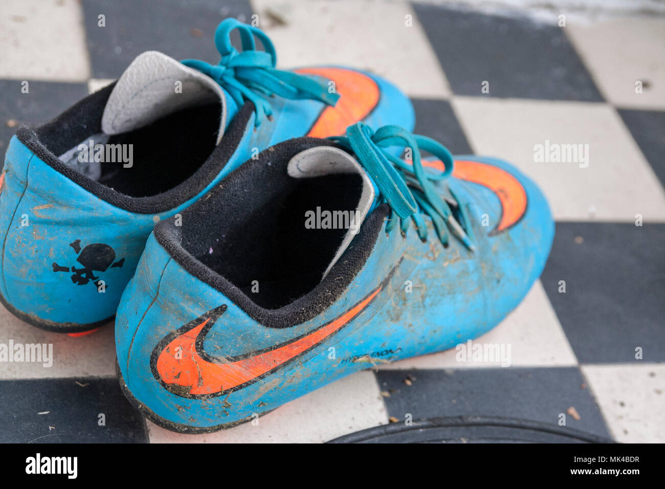 Coppia di bambini scarpe da calcio, kids scarpe da calcio muck, mucky, nike,  blu e arancione, concetto di infanzia, gioventù concetto, health fitness  soccer kids Foto stock - Alamy