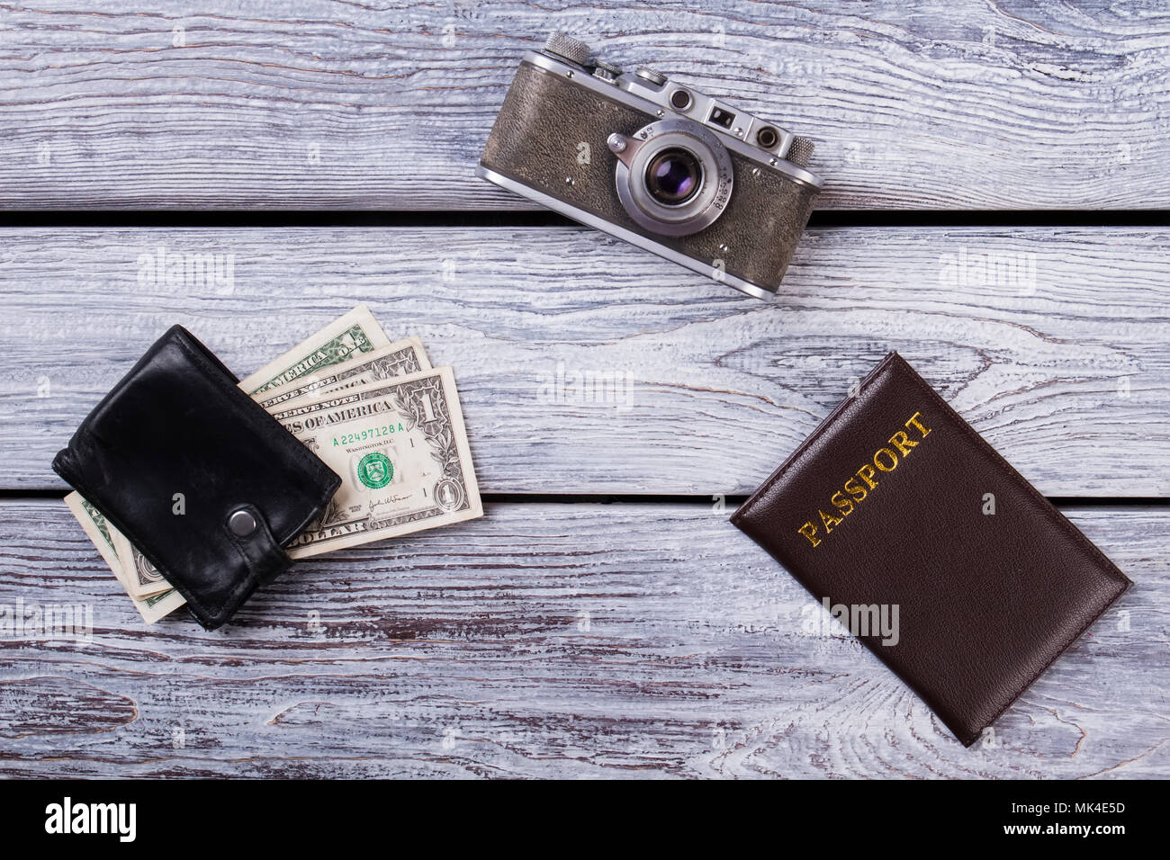Travel Essentials laici piana. Fotocamera Vintage, il passaporto e il portafoglio con denaro, vista dall'alto. Foto Stock