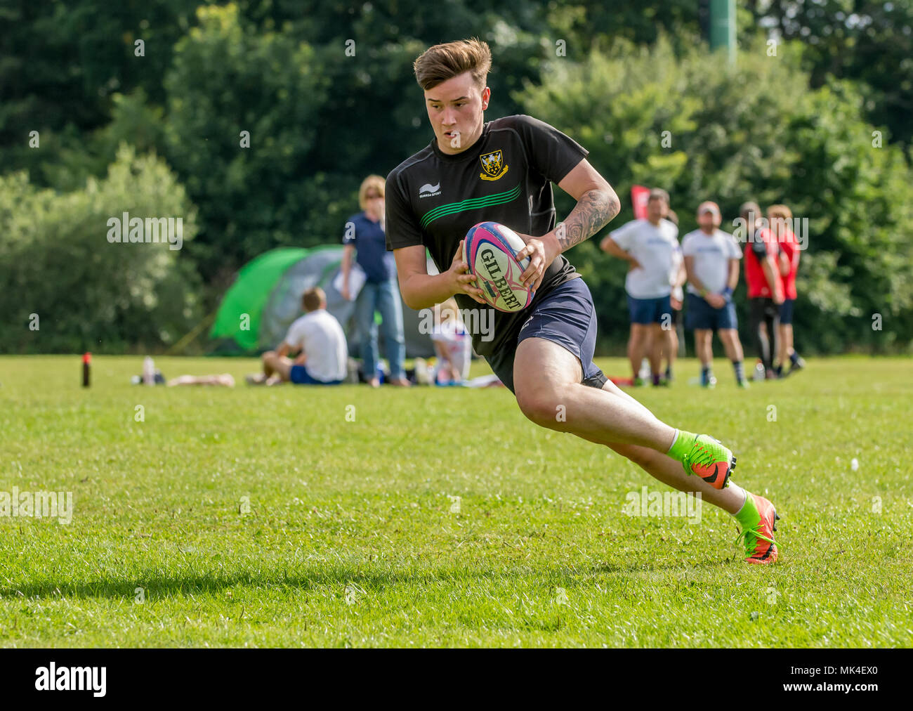 Amatoriale touch rugby torneo - player virando verso il lato che porta la palla in entrambe le mani Foto Stock