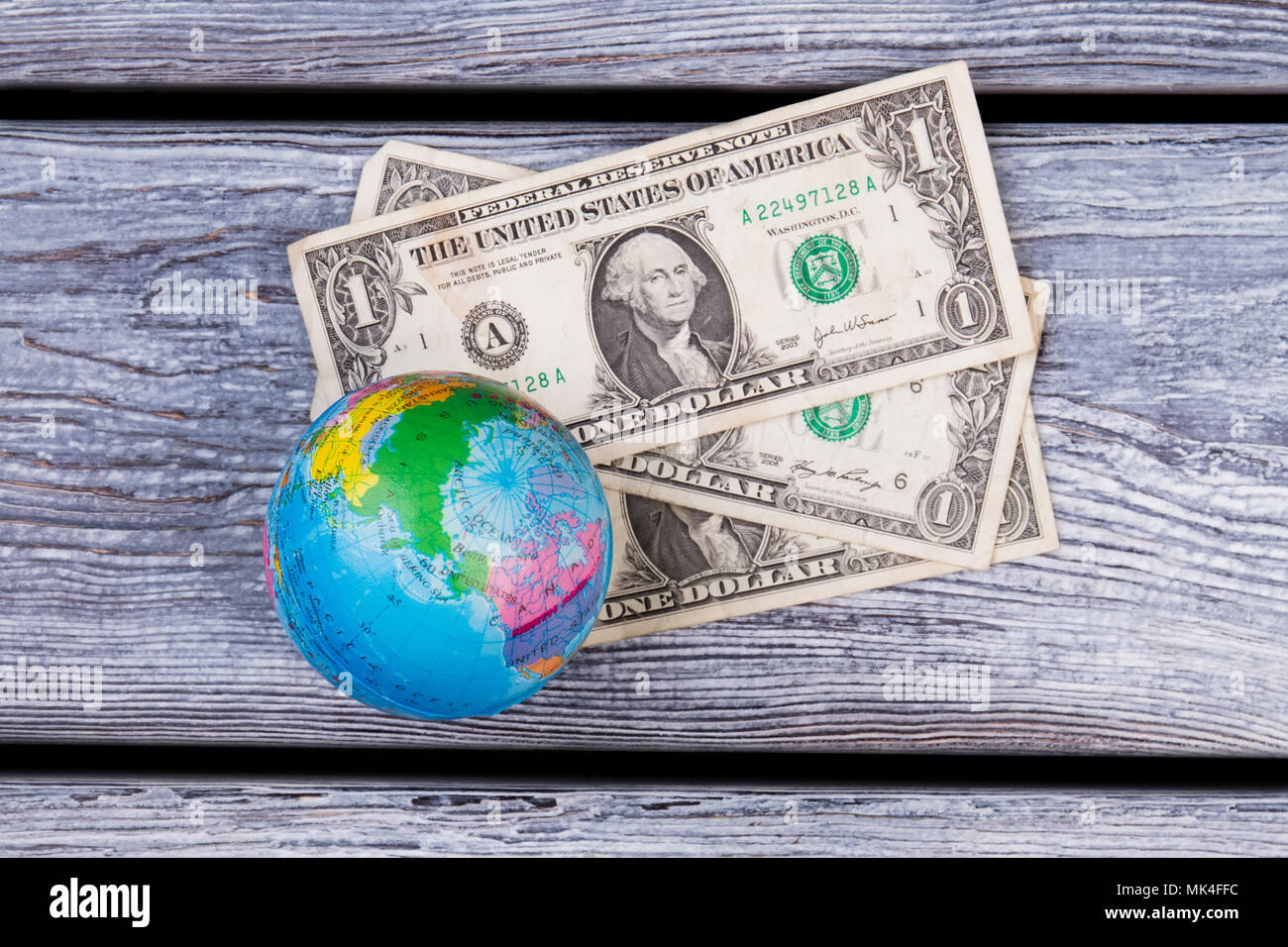 Globo e denaro laici piana. Dollari americani e globo sulla scrivania in legno superficie. Foto Stock