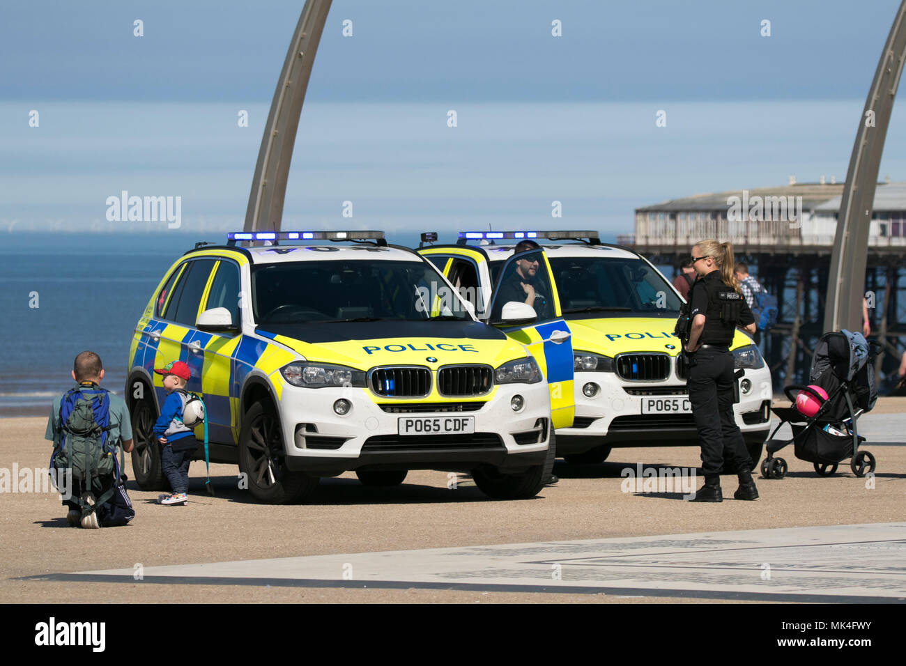 Polizia armata a interagire con il pubblico in generale sulla passeggiata sul lungomare di Blackpool Foto Stock