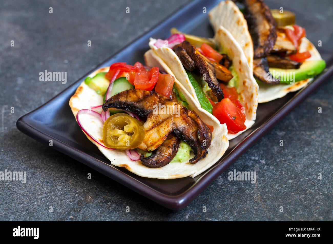 Vegan tortillas con funghi, avocado, Cipolline borretane e cetrioli Foto Stock