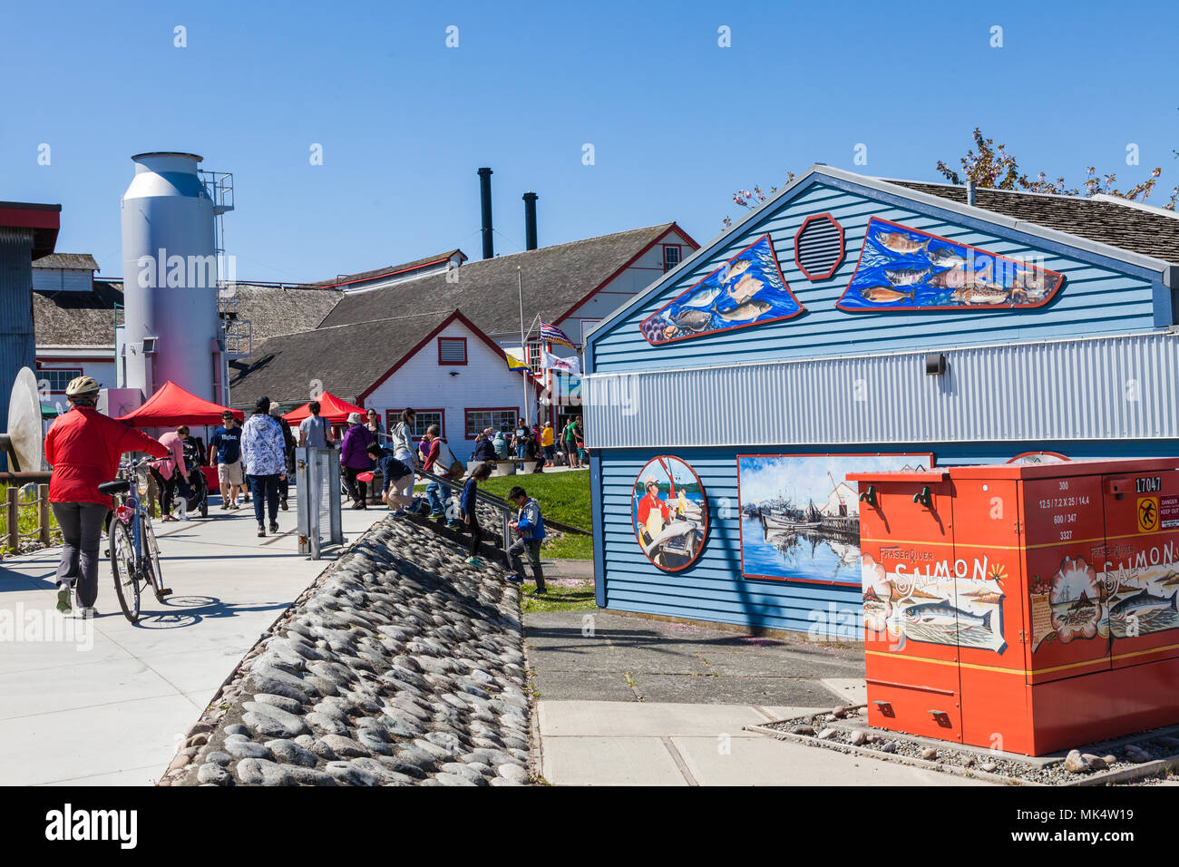 Turisti e spettatori locali voce ad un luogo di divertimento accanto a un pesce cannery in Steveston, British Columbia Foto Stock