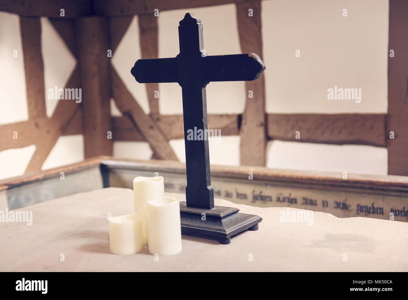 Una croce di legno all'interno di un edificio tradizionale simboleggia la fede e la spiritualità. Foto Stock