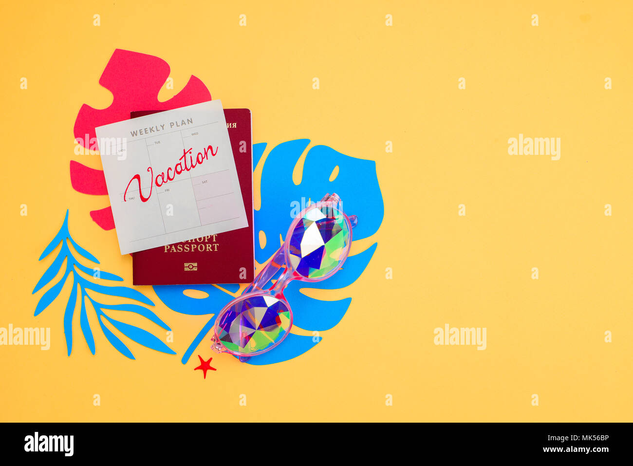 La vacanza estiva laici piatta con accessori da spiaggia tropicale e foglie su un vivace sfondo giallo. Travel Essentials dal di sopra con copia spazio. Mode Foto Stock