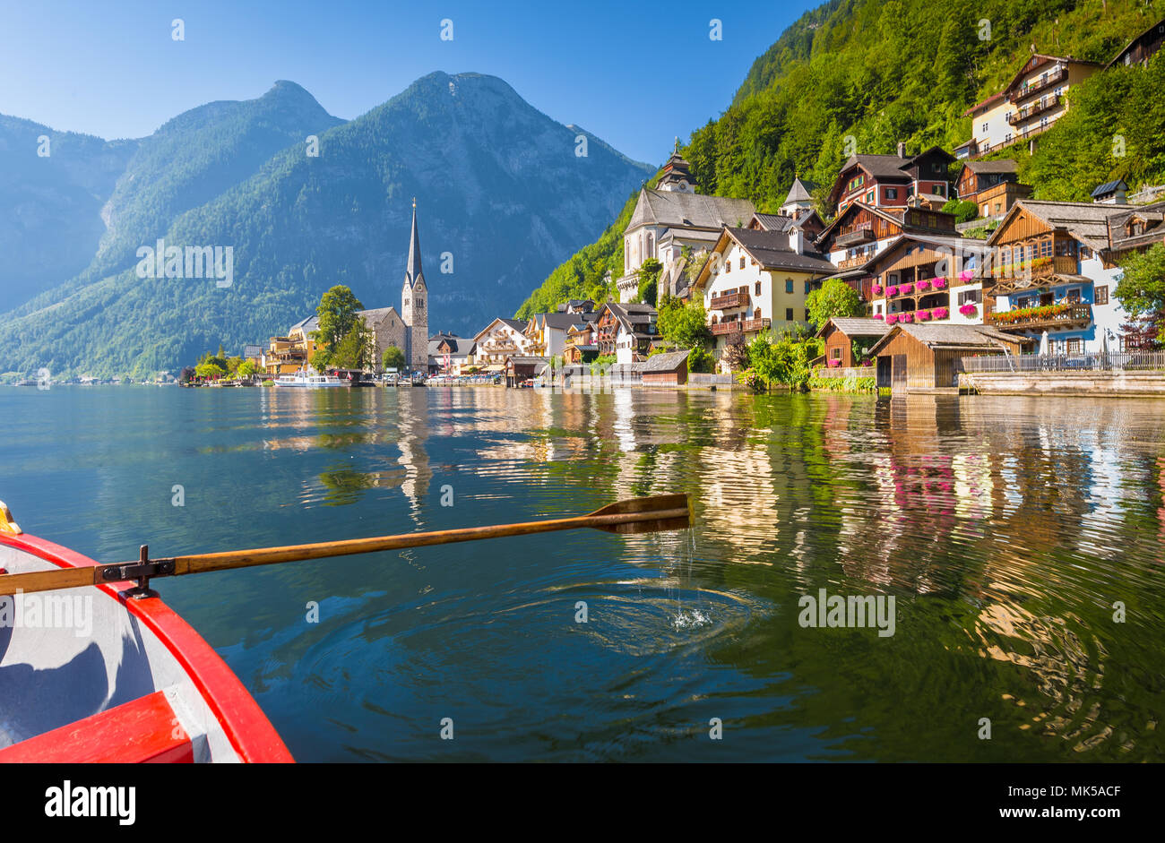 Scenic vista da cartolina famosa Hallstatt borgo lacuale nelle Alpi austriache con legno tradizionale barca a remi in estate, Austria Foto Stock