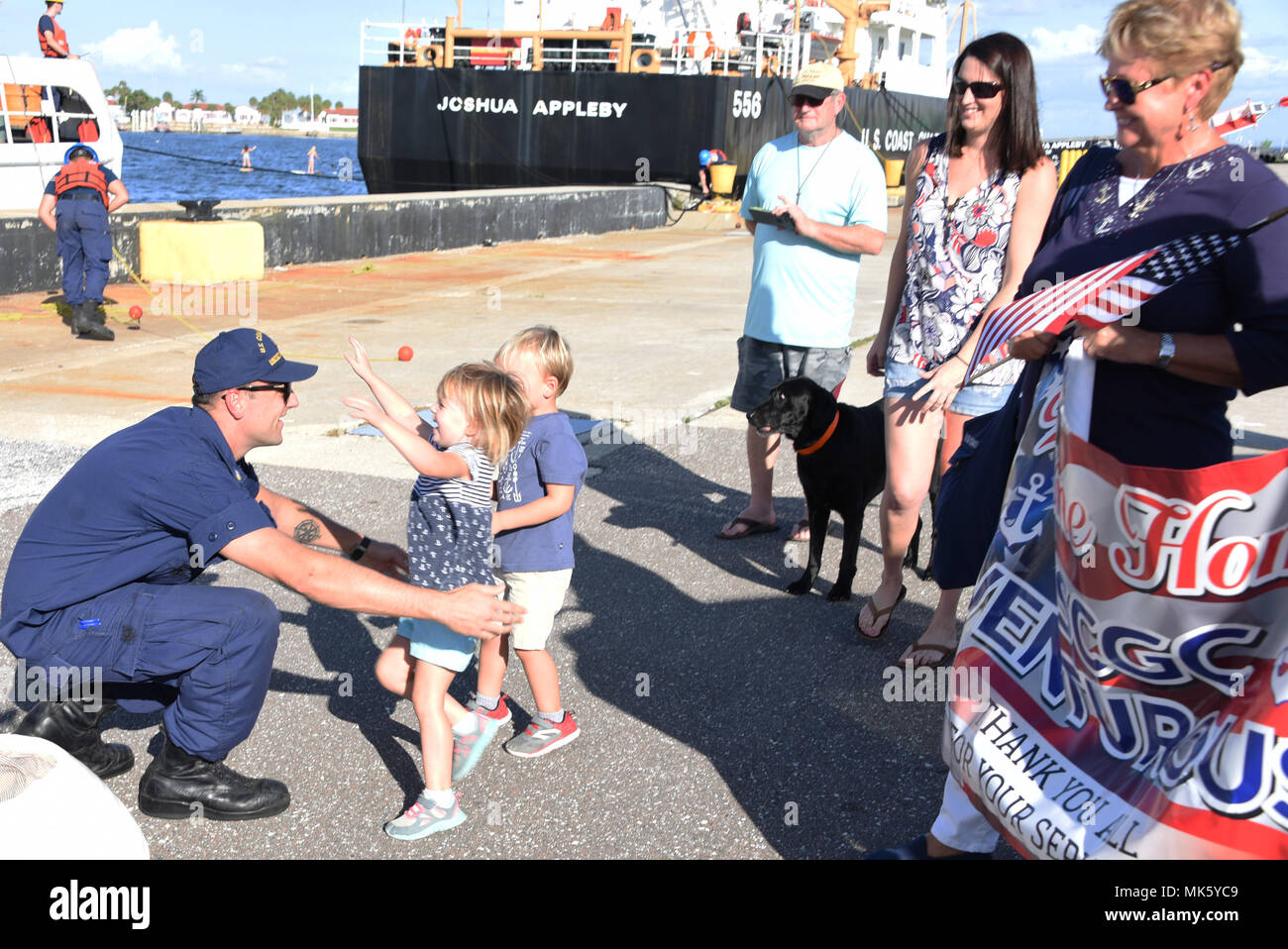 Petty Officer 2a classe Ryan Steiger, un membro dell'equipaggio a bordo del guardacoste Venturous, è accolto a casa dai suoi figli, la famiglia e gli amici di San Pietroburgo, Florida, nov. 13, 2017. L'equipaggio di venturous è tornato a casa dopo un 69-giorno patrol conducendo Hurricane Relief e le operazioni di polizia nel Mar dei Caraibi. (U.S. Coast Guard foto di Sottufficiali di seconda classe Ashley J. Johnson). Foto Stock