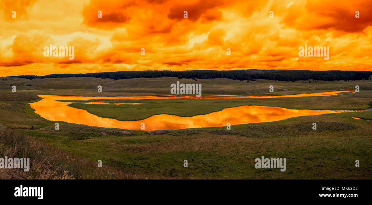 Tramonto sul fiume in una vasta gamma di campi aperti. Il fiume che riflette il colore del cielo. Panoramica. Foto Stock