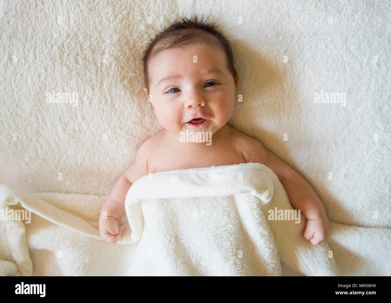 Carino baby boy nel letto sotto una coperta Foto Stock