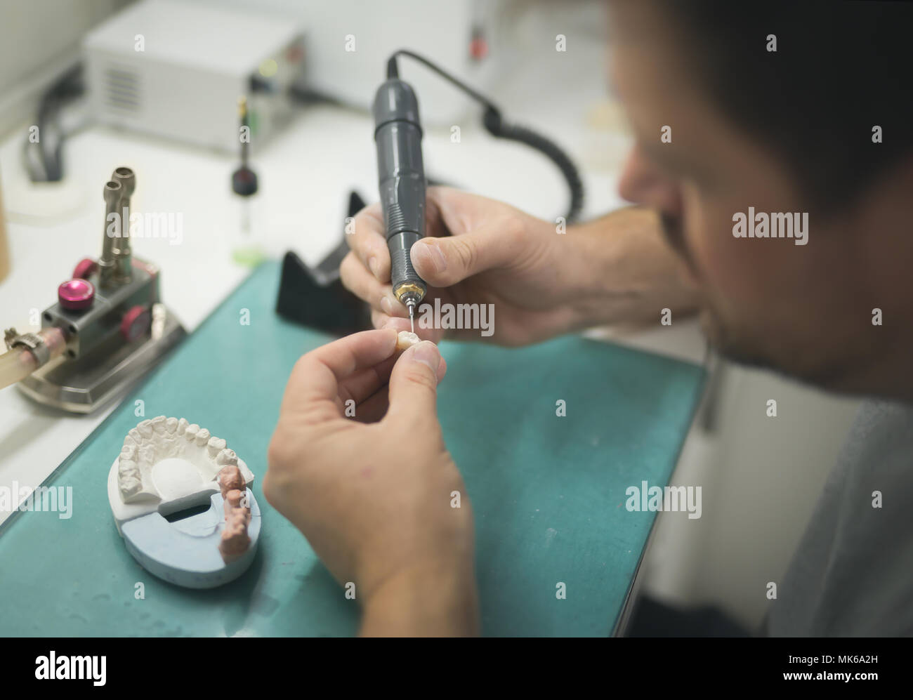 Dente artificiale che viene svolto da una protesi dentaria specialista. Foto Stock