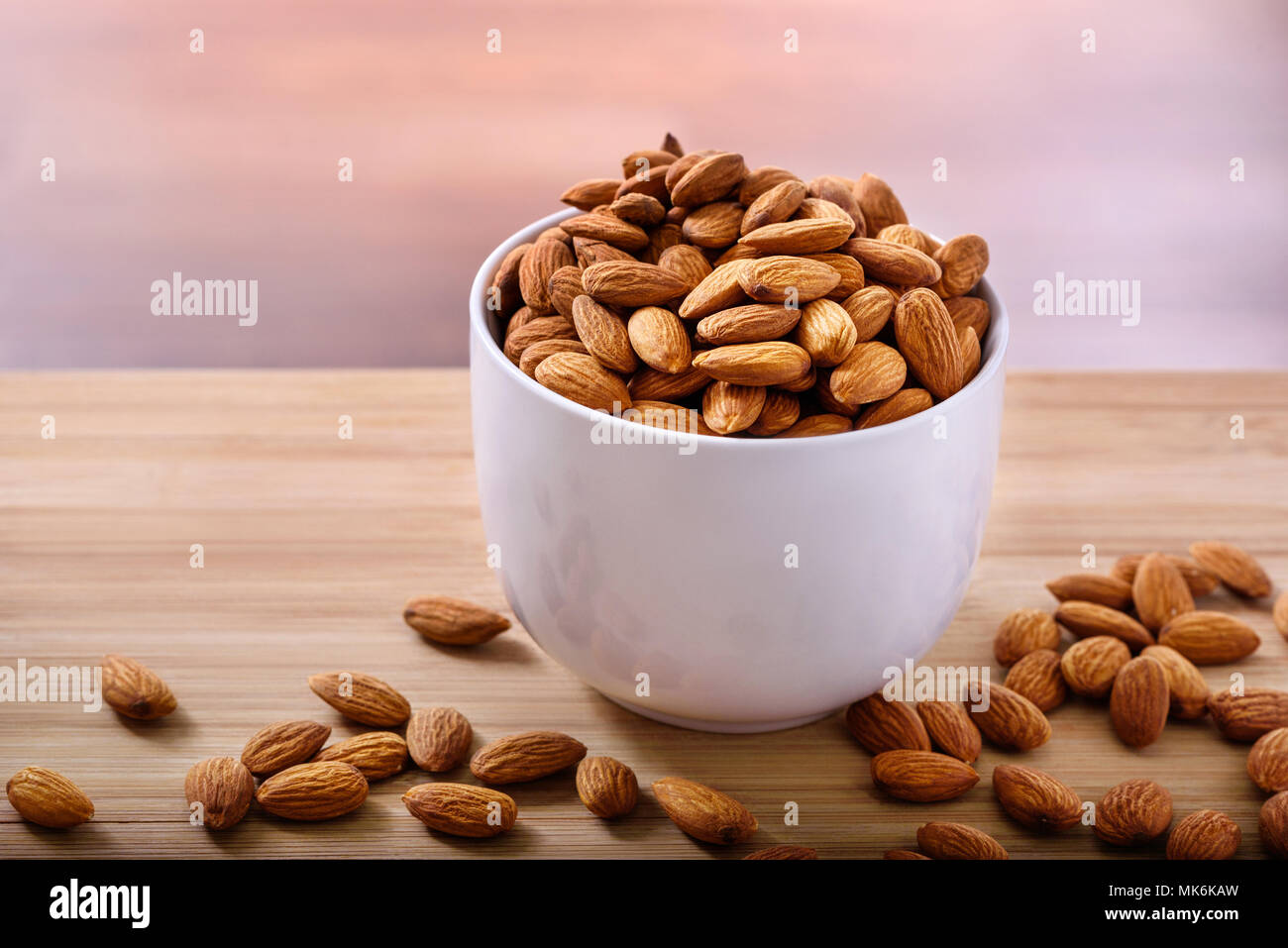 Ciotola di mandorle crude su sfondo rustico Foto Stock