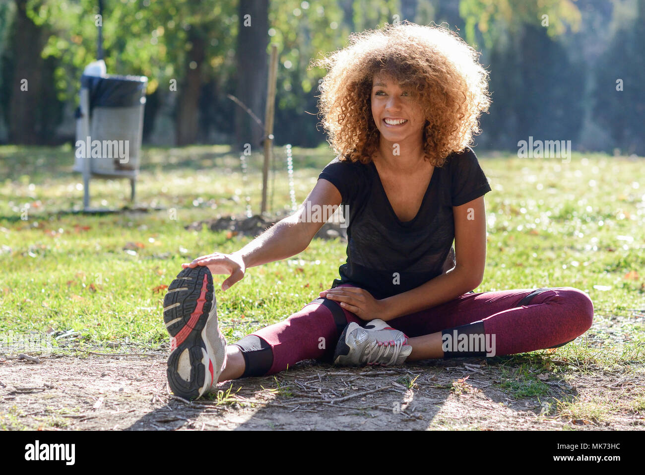 Giovane nero fitness runner donna gambe stretching dopo la corsa Foto Stock