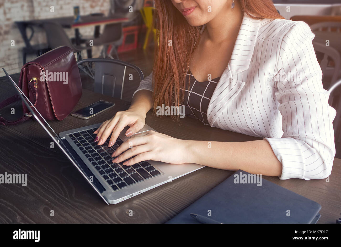 Chiudere le donne d'affari tipo sui notebook e hanno un memo libro e penna e vetro sulla tavola di legno in corrispondenza dello spazio di lavoro hanno raggi di luce solare da finestra Foto Stock