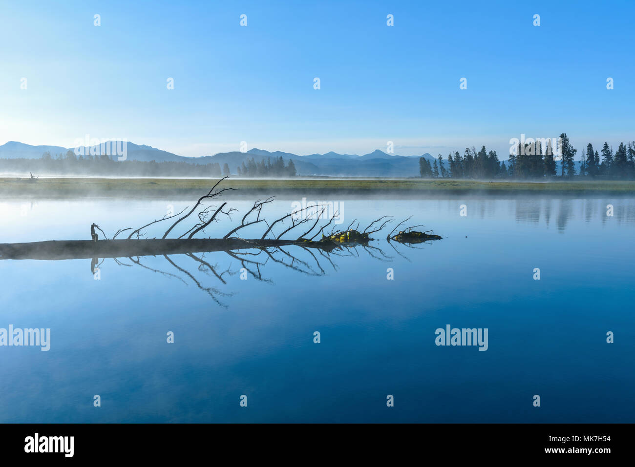 Misty Lago Blu - Mattino sole risplende su di una remota misty lago di montagna. Foto Stock